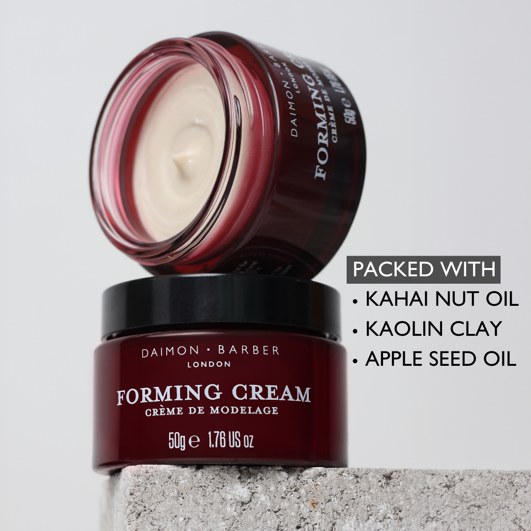 Open jar of Forming Cream on top of another with ingredients listed on grey background.