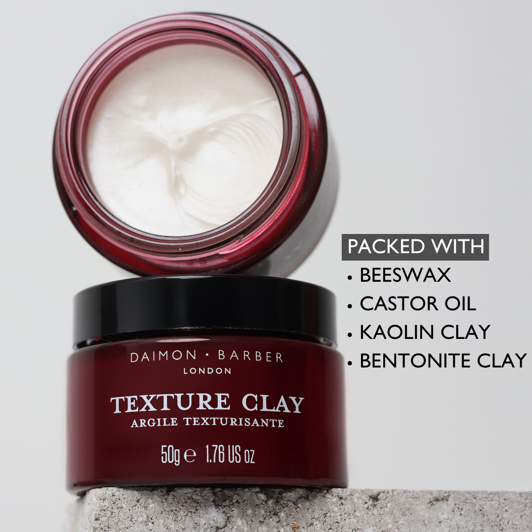Shot of open Texture Clay on top of closed jar with list of ingredients on grey background