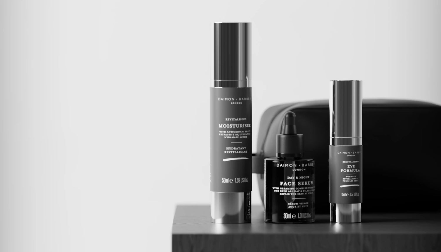 A men's skincare product assortment in front of a black leather toilet bag
