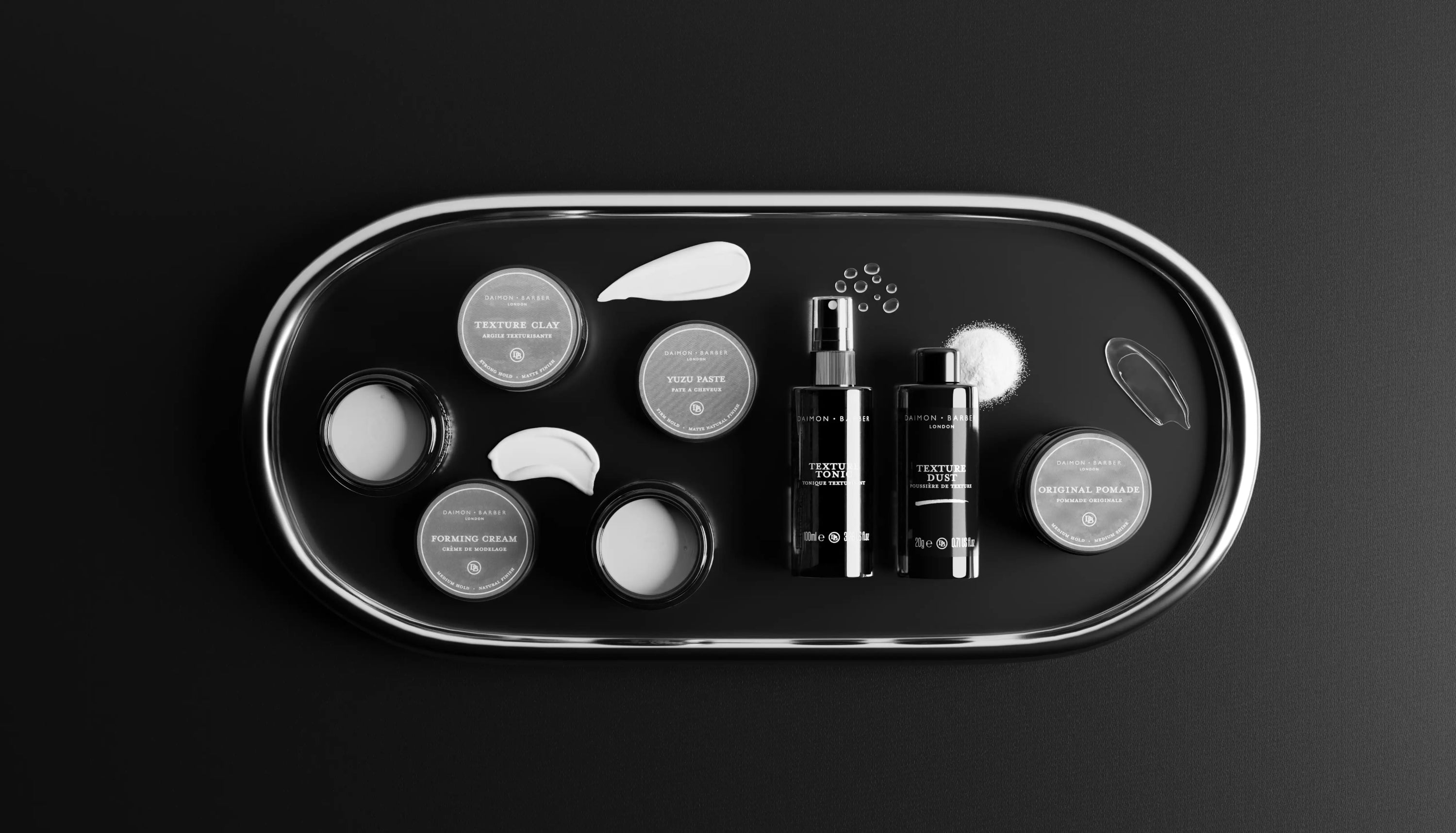 Collection of men's hair styling products on a tray in black and white