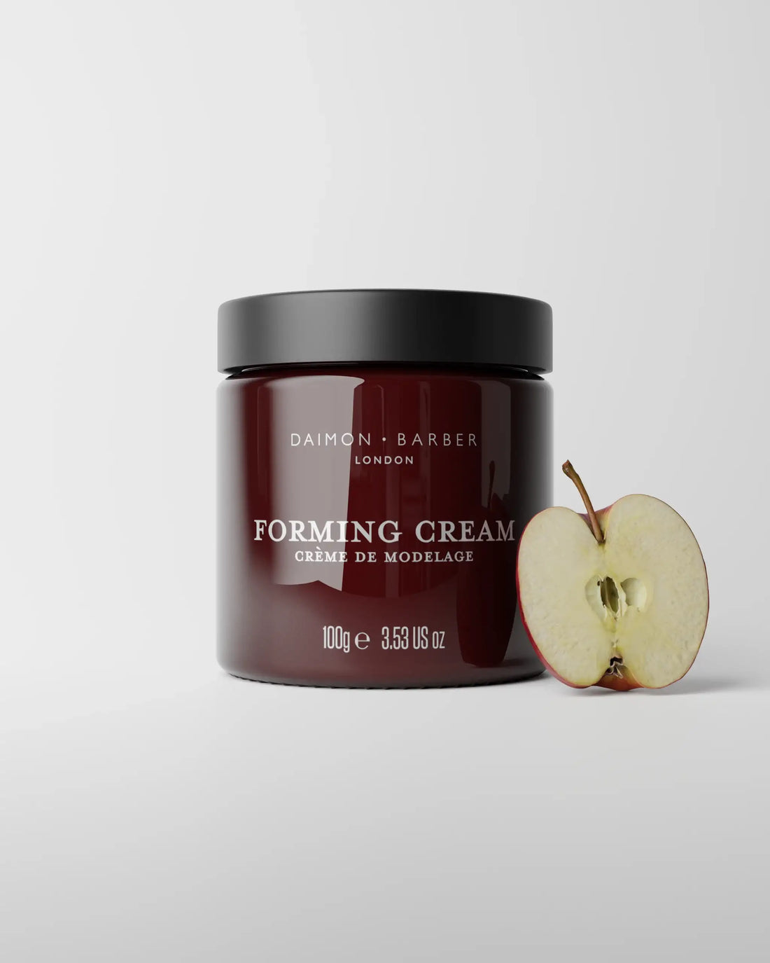 Jar of 100g Forming Cream with apple on grey background.