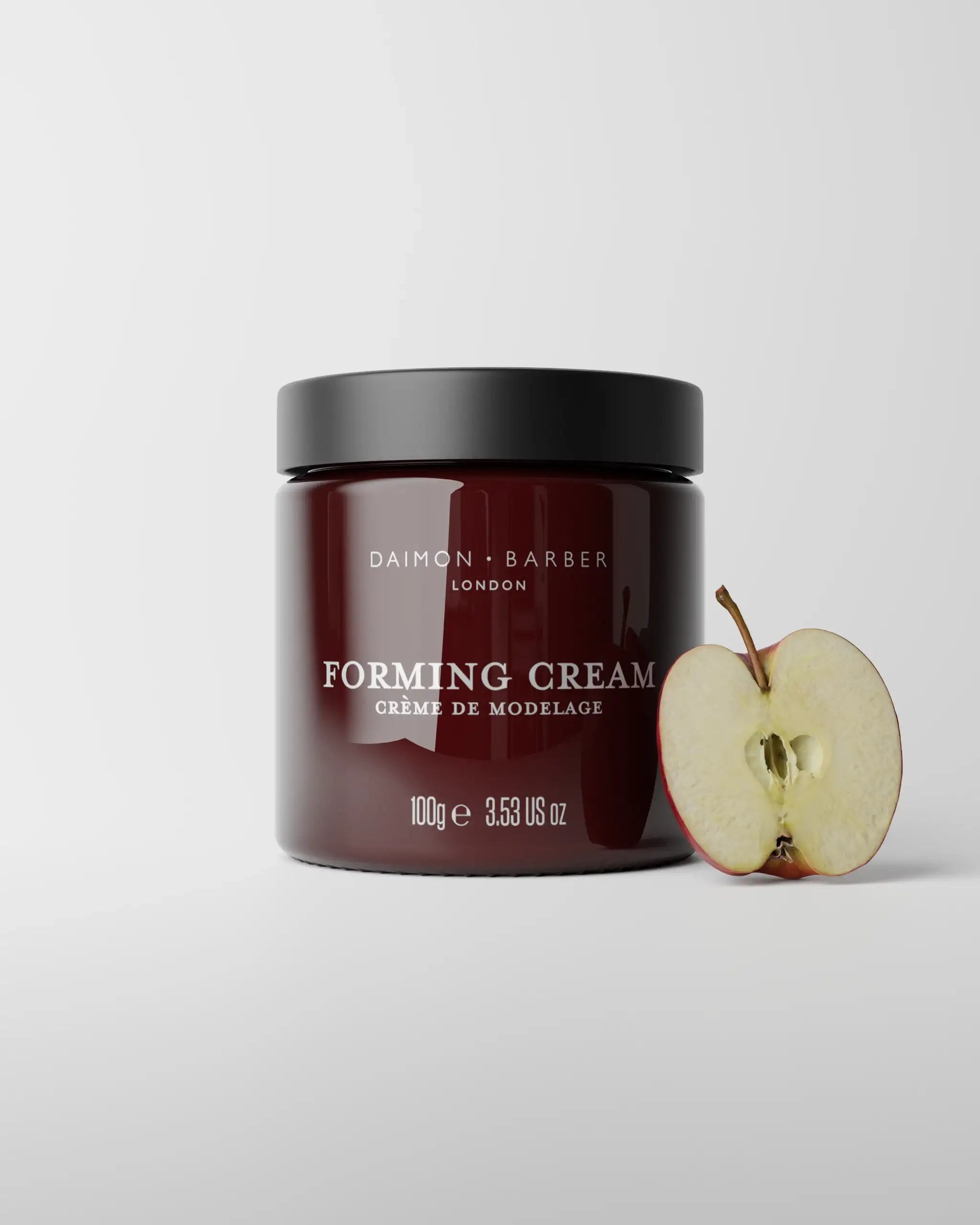 Jar of 100g Forming Cream with apple on grey background.