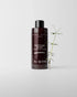 Bottle of Daimon Barber Texture Dust on grey background with small plant