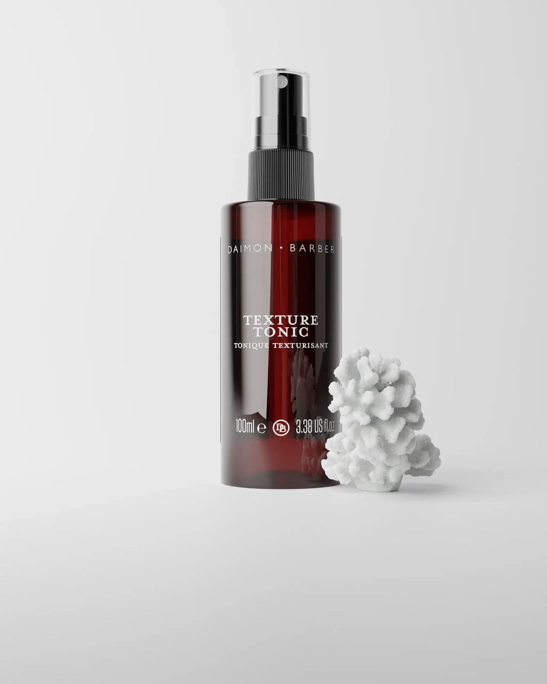 Texture Tonic bottle on grey background with piece of coral