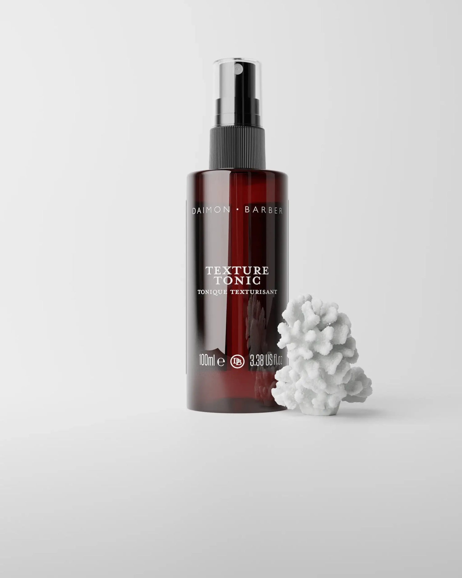 Texture Tonic bottle on grey background with piece of coral