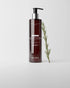 Bottle of Advanced+ Conditioner with a pump and a sprig of rosemary on a light grey background.