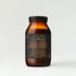 Amber glass collagen supplement bottle with decorative label on a light gray background
