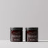 Two claret hair styling product jars labeled Daimon Barber Texture Clay, shown side by side on a light gray surface against a neutral gray background.